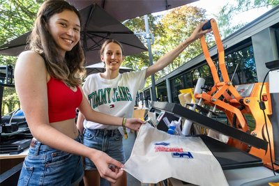 Olivia-Sophie Mühler und Chantal Hillig (v. l.) bedrucken im „FabMobil" eine Tragetasche mit eigenen Motiven.