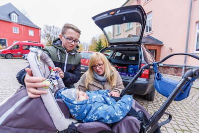 Stefanie Wittig hat schon Probleme, Ewen und seinen kleinen Reha-Buggy ins Auto zu bringen. Wenn Bruder Elias dabei ist, hilft er.