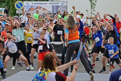 Eine gemeinsame Aufwärmung: Anja Hausmann vom Fitness-Team bereitet die Teilnehmer auf den Lauf vor.
