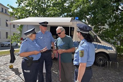 Klaus Ungethüm (Mitte, rechts) hat am Polizeimobil in Eibenstock vorbeigeschaut und kam ins Gespräch mit Kerstin Schröder (links), Bürgerpolizist Frank Groß und Kathy Seyferth. 