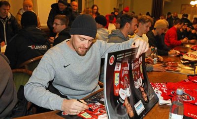 Eispiraten-Profi André Schietzold beim signieren eines Fankalenders.