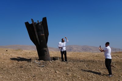 Menschen neben dem Wrack einer iranischen Rakete, die im Westjordanland eingeschlagen ist. 