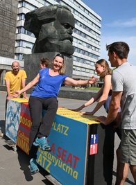 Ulrike Voigt auf einer der neuen Bänke, die am Karl-Marx-Kopf aufgestellt worden sind. 