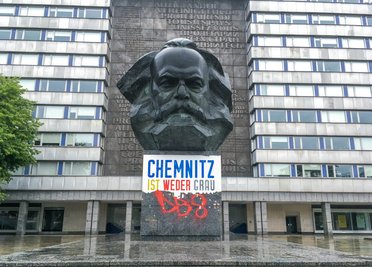 Das Plakat mit der Aufschrift «Chemnitz ist weder grau noch braun» am Karl-Marx-Denkmal wurde teilweise abgerissen. ..