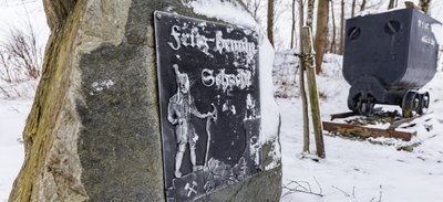 Ein Gedenkstein am Parkplatz des Freizeitbades Geyer erinnert an Fritz Hennig, der einst die Idee hatte, Grubenwasser für die Bewirtschaftung des Fußballplatzes zu nutzen. Die Tour führt auch an dieser Erinnerungsstätte nahe des Fritz-Hennig-Schachts vorbei. 