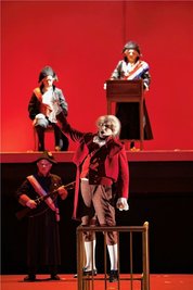 Traditionelle Kostüme vor blutrotem Hintergrund: Szene aus "Dantons Tod" im Theater Gera. 