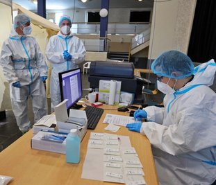 Sven Franke, Tom Menzel und Raphael Püschmann (von links) arbeiten im Testzentrum von Hohenstein-Ernstthal im Schützenhaus am ersten Feiertag Hand in Hand. 