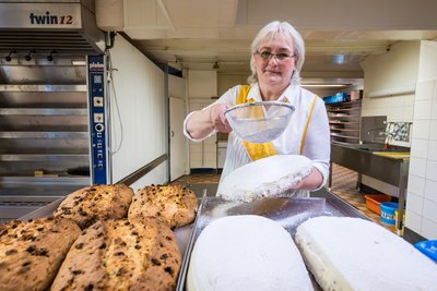 Kerstin Schönfelder zuckert einen der Stollen aus der Bäckerei in Carlsfeld.