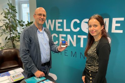IT-Amtsleiter Michael Walter und Anna-Maria Hübner vom Welcome-Center mit dem KI-Übersetzer Pocketalk „S“.