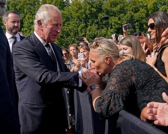 Rundgang vor dem Buckingham-Palast in London: Eine Frau küsst die Hand von König Charles III. Der neue König war nach dem Tod von Elizabeth II. aus Schottland zurückgekehrt. 