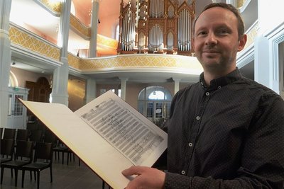 Kirchenmusikdirektor Ulrich Meier mit den Noten des von ihm editierten Schmidt-Motettos.Foto: Joachim Thoß