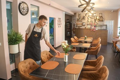 Dmytro Yevpatov deckt die Tische ein. Der 17-jährige Ukrainer arbeitet im Restaurant und zudem an seinem Abitur.