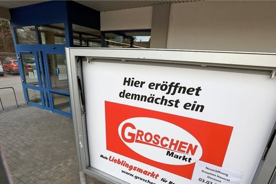 Auf der Tafel wird die Eröffnung des Groschen-Marktes in Meerane angekündigt. 
