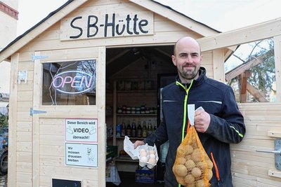 Michael Ehrhardt zeigt Kartoffeln und Bio-Eier, die derzeit in der SB-Hütte besonders gefragt sind.