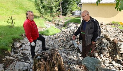Michael Buntin (rechts) und Uwe Groh stehen inmitten der angespülten Sedimente. Nicht nur in diesem Bereich hat sich das Bett vom Ruderitzbach nach dem Starkregenereignis verändert. Beide hoffen nun auf Hilfe vom Bauhof. 