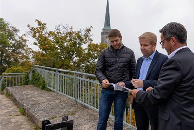 Stadtbaudirektor Thomas Ebert und Bürgermeister Marco Siegemund erläutern dem Landtagsabgeordneten Sören Voigt (von links) auf dem Aussichtsplateau des Falkensteiner Schlossfelsens die Pläne der Stadt zu dessen Sanierung.