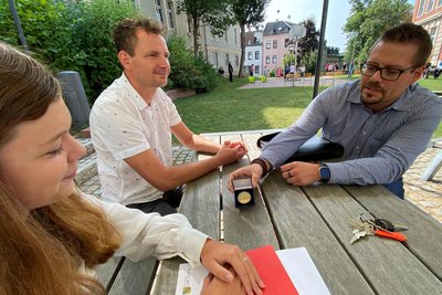 Überraschung im Hof des Schulteils Friedensschule. Schulleiter Christian Reinsch (rechts) überreicht Lena Duda die Schulmedaille des Goethe-Gymnasiums - als Auszeichnung für „außergewöhnliche Leistungen“. Darüber freut sich auch Spanischlehrer Kevin Thoß.