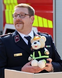 Mario Legies, Chef des Kreisfeuerwehrverbandes, hat ein Maskottchen für das neue Fahrzeug mitgebracht.