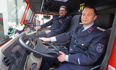 Maschinist Jens Domann (vorn) und Wehrleiter Rico Leuschner von der Freiwilligen Feuerwehr Hohenstein-Ernstthal freuen sich über das neue Fahrzeug mit dem Riesen-Löschwassertank.