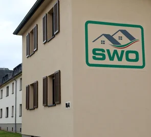 Das Stadtwerke-Logo an einem renovierten Haus in der Abteisiedlung in Oberlungwitz. Die Vermietung von Wohnungen in Mehrfamilienhäusern und Plattenbauten sind nur ein Teil des Leistungsspektrum. 