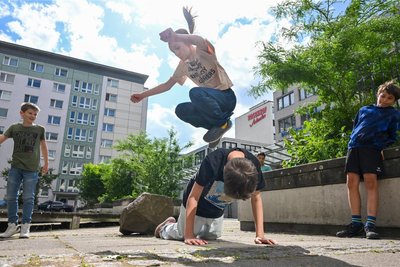 Gemeinschaft und gegenseitige Unterstützung ist beim Parkour wichtig. Die Kinder sind erst gegenseitig über sich drüber gesprungen, bevor sie über den Stein im Hintergrund springen wollten.