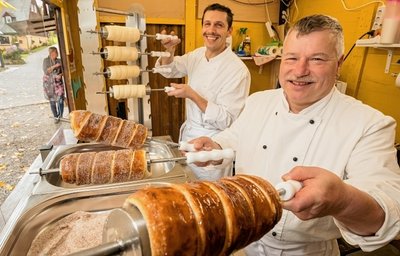Gerd Weidner (vorn) und André Schubert backen auf dem Seiffener Sternenmarkt Baumstriezel. 