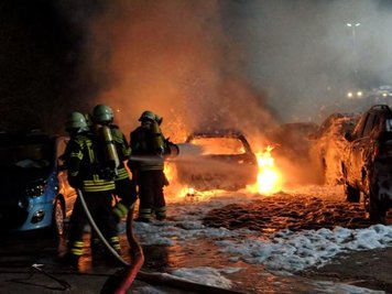 Brandeinsatz auf dem Mitarbeiterparkplatz der FSG in Oelsnitz: Ein Auto brannte lichterloh, zehn weitere Pkw wurden wegen der Hitze mehr oder weniger stark beschädigt.