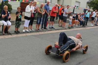 Ein Foto von 2022: Werner Fröse, damals 82, fuhr quasi auf einem Brett liegend die Strecke hinab – und gewann das Seifenkistenrennen im vogtländischen Syrau.