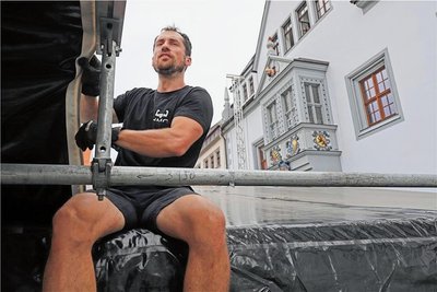 Bühnenbauer Konstantin Grimmer zieht eine Plane in das Dach der Obermarkt-Bühne.