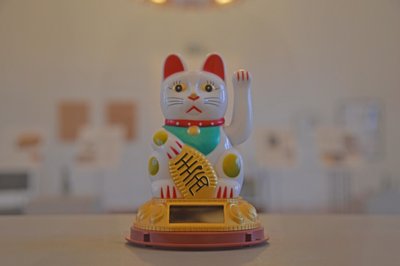 Winkekatzen, hier ein Exemplar aus der Ausstellung, sind Glücksbringer.