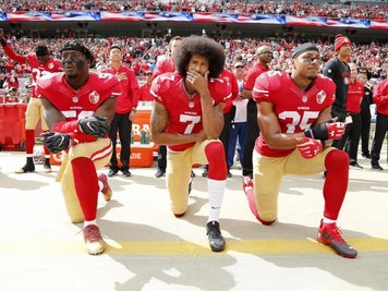  
          Colin Kaepernick (M.) kniete 2016 mit seinen Teamkollegen Eli Harold (l) und Eric Reid vor einem Spiel der San Francisco 49ers.
