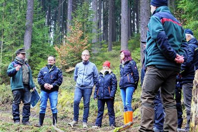 Revierförster Sascha Barthel (links) informierte vor dem Arbeitseinsatz die Mitglieder des Heimatvereins Zwota und Klingenthals Oberbürgermeisterin Judith Sandner (5. von links) über die weiteren Vorhaben im Glasbachtal.