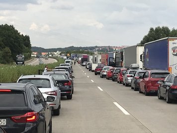 Nach einem Autobrand kommt es auf der A4 zu Stau. Autofahrer halten die Rettungsgasse ein.