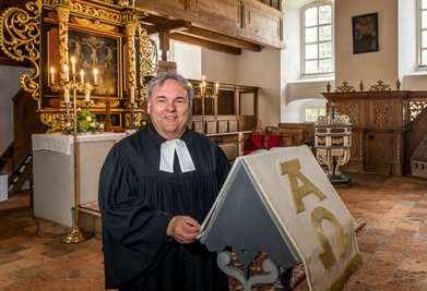 Von außen eher schlicht gehalten, beeindruckt sie vor allem mit ihrer Innenausstattung: die Exulantenkirche in Oberneuschönberg. Pfarrer Stefan Klotz freut sich, dass sie in diesem Jahr zu den Stationen der Orgelfahrt gehört.