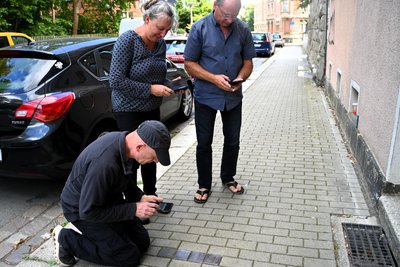 Gustav-Adolf-Straße in Plauen. Ines und Mario Nixdorf entschuldigen sich, dass die Stolpersteine nicht geputzt sind und zeigen Bilder mit Blumen und Bildern vom Marsch des Lebens 2023.