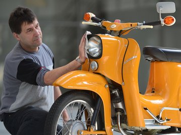Eine Simson Schwalbe wird im Fahrzeugmuseum in Suhl (Thüringen) von Museumsmitarbeiter Horst Sosnowski poliert. 