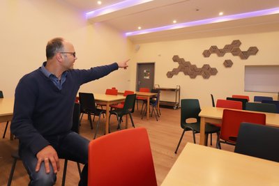 David Bojack weist auf die Paneele im Co-Living-Space der Grundschule Hilbersdorf hin.