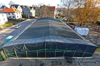 Abriss des Asbest-Hortes dauert länger - Folie umhüllt den Hort. Sie verhindert, dass die gefährlichen Asbestfasern in die Außenluft gelangen. Es gibt eine Sicherheitsschleuse. Die Arbeiter müssen sie passieren, um ins Innere des Gebäudes zu gelangen.