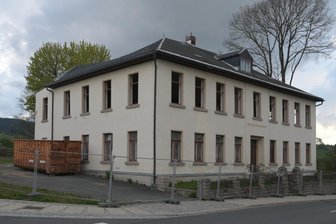 Abriss schafft in Eibenstock Platz für Wohnen am Stadtpark - Bauzaun und Container stehen für den Abriss bereit, Fenster wurden ausgebaut. 