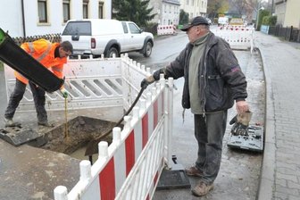 Abschied von der Umleitung: B 101 ab Donnerstag frei - Am Dienstag war Danino Vogel (l.) vom Chemnitzer Verkehrsbau noch mit dem Verfüllen der Schlüsselstangen für die Hauswasseranschlüsse beschäftigt. Ronald Gellrich, Mitarbeiter der Firma Breitenauer Transportbeton, hatte hierfür den erforderlichen Betonmörtel angeliefert.