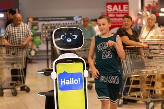 „Achtung, ich muss hier durch“: In diesem Supermarkt gibt es jetzt einen der ersten Einkaufsroboter des Vogtlands - Noah (12) aus Schwarzbach rennt „Globy“ hinterher. Der ist aber ganz schön flink.