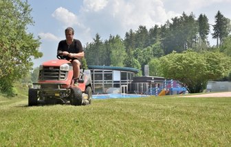 Adorf pflanzt pro Badegast einen Baum - Hübsch machen für den Saisonstart: Rainer Neudeck vom Stadtbauhof Adorf mäht den Rasen im Waldbad, das am Montag öffnet.
