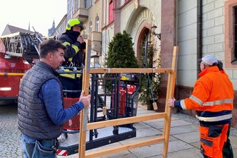 Feuerwehrchef René Schröter und Mitarbeiter des Bauhofs der Stadt Mittweida haben am Mittwochmorgen mit der Drehleiter das Türchen mit der Nummer 24 am Rathaus montiert.