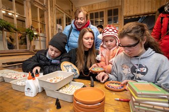 Adventsmeile in der Elsteraue lockt überregionales Publikum nach Plauen - Zwischen zahlreichen Kleinkunstangeboten auf der Adventsmeile konnten sich Kinder bei Mosaikdesigner Elisabeth Kühnast (Mitte) selbst ausprobieren. Maximilian (links) mit Mama Karolin Meßner sowie Mila und Klara fertigten schon erste Weihnachtsgeschenke.