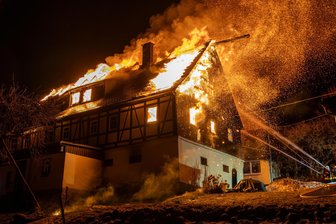 Ältestes Haus in Dorf im Erzgebirge brennt nieder: Die Bilder des Feuerwehreinsatzes - Flammen schlagen aus dem Dach eines Bauernhauses. Rund 70 Einsatzkräfte haben am Montag stundenlang in Waschleithe gekämpft.