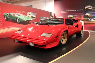 Der Lamborghini Countach 400 S von 1981 punktet zwar mit zwölf Zylindern, 355 PS und 309 km/h Spitze. Anders als es aussieht, zieht er jedoch in Sachen Aerodynamik nur sehr bedingt den Hering vom Teller. Da ist ihm der zwei Jahre später auf den Markt gekommene Audi 100 C3 (Bildhintergrund) deutlich überlegen. 