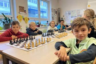Aidan gewinnt Kinderschachturnier in Zwickau – Kita „Regenbogenland“ jubelt über Pokal und Teamgeist - Beim Kinderschachturnier in Eckersbach. Im Hintergrund mit blauem T-Shirt der spätere Sieger, Aidan Onyia aus der Kita „Regenbogenland“.