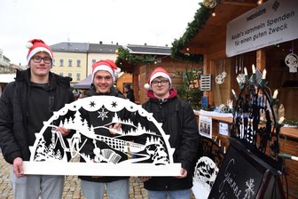 Aktion für „Leser helfen“ auf dem Plauener Weihnachtmarkt - Die Auszubildenden Erik Danner, Niklas Dörfel und Randy Müller von der Firma Meiser zeigen einen der Lichterbögen, die für die Aktion „Leser helfen" der Freien Presse auf dem Weihnachtsmarkt in Plauen verkauft werden.