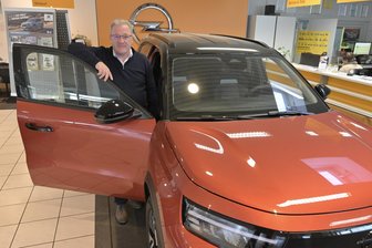 „Alle warten auf die Prämie“: Warum E-Autos in Westsachsen derzeit nur zögerlich gekauft werden - Volkmar Stöcker, einer der Geschäftsführer von Zimpel & Franke, in der Friedrichsgrüner Filiale an einem rein elektrischen Opel Frontera E in Canyon Orange.