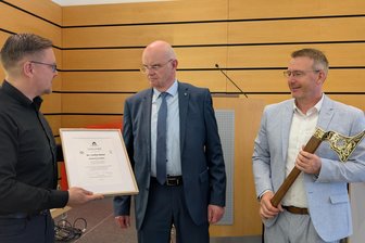 Aller guten Dinge sind drei: Welterberegion Erzgebirge hat jetzt drei Sonderbotschafter - Steve Ittershagen (l.) und Sven Krüger (r.) überreichen die Urkunde und Ehrenbarde zum Sonderbotschafter der Montanregion an Lothar Beier.